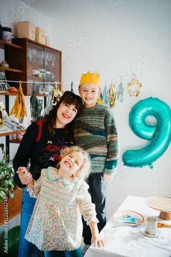 Boy 9th birthday party portrait at home with mother and sister photo