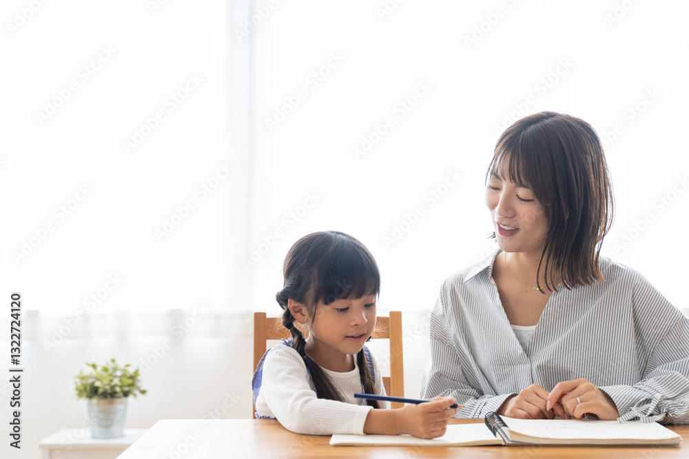 勉強する女の子と見守る母 勉強する女の子と見守る母