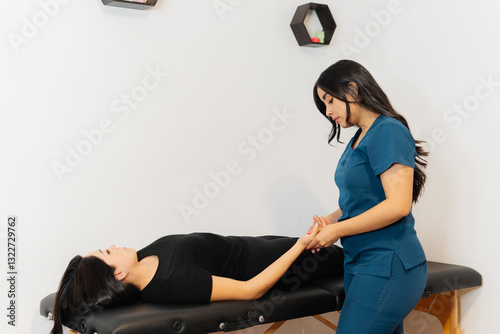 Physiotherapist massaging the palm of a woman's hand. photo