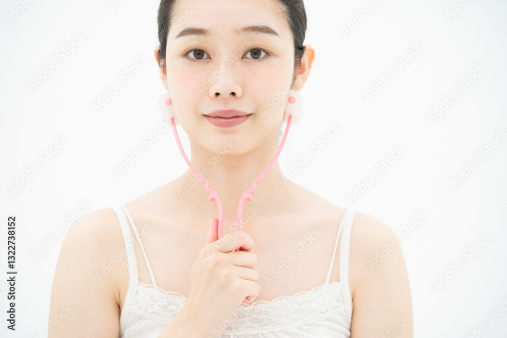 小顔マッサージ器具を使う女性