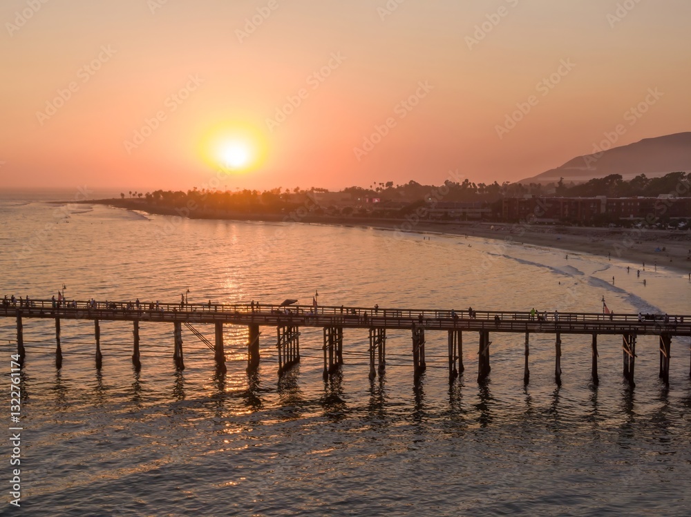 Aerial view of people enjoying the sunset on the Ventura Pier in California, USA. Tourists and locals visit the pier for recreation and scenic views. Aerial view of people enjoying the sunset on the Ventura Pier in California, USA. Tourists and locals visit the pier for recreation and scenic views.