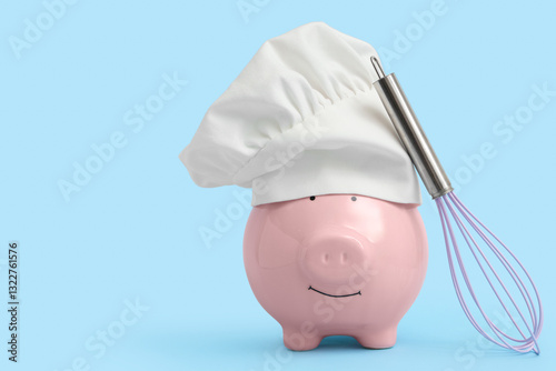 Piggy bank in chef's hat wi...