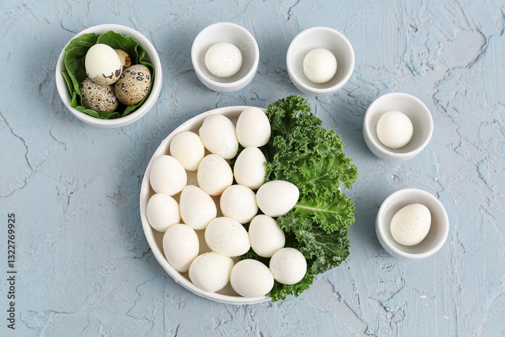 Plate and bowls of fresh boiled quail eggs with lettuce on blue background Plate and bowls of fresh boiled quail eggs with lettuce on blue background