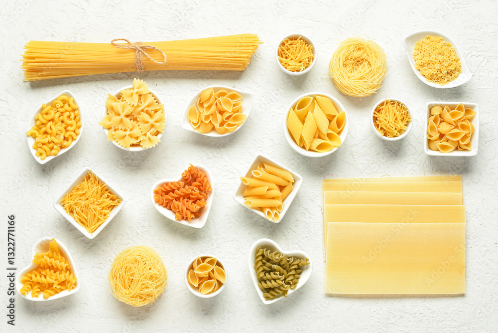 Bowls with different tasty uncooked pasta on light background Bowls with different tasty uncooked pasta on light background