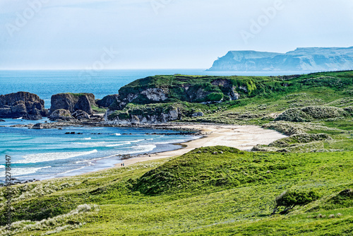 White Park Bay on north Antrim coast, Northern Ireland. Central mound in sand dunes is prehistoric burial site with peristalith stones. Looking N.E.