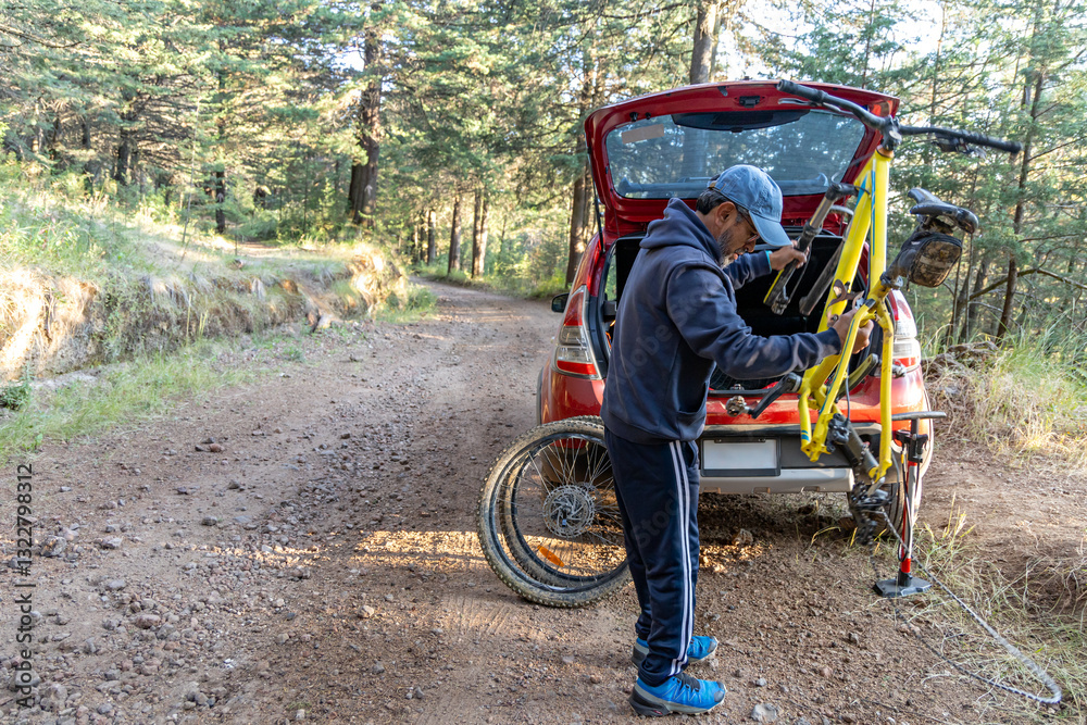 Mature adult male setting up his bike for mountain biking Mature adult male setting up his bike for mountain biking