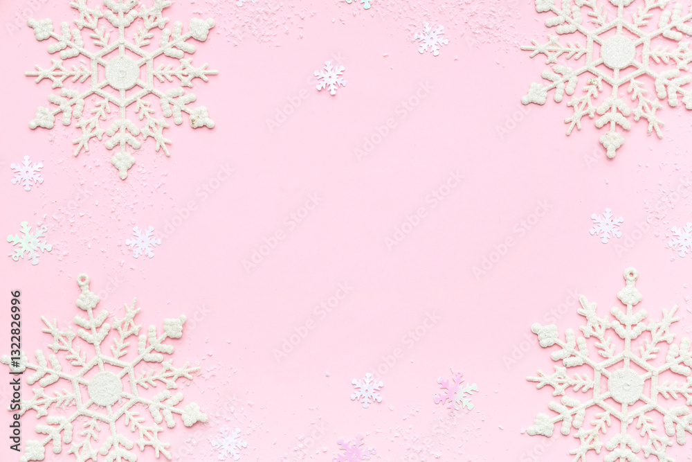 Frame made of beautiful decorative snowflakes and snow on pink background Frame made of beautiful decorative snowflakes and snow on pink background