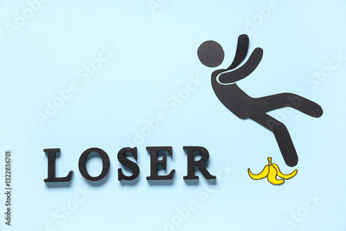 Word LOSER with falling paper human figure and banana peel on blue background