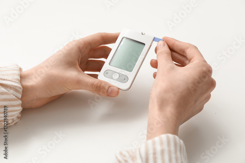 Female hands with digital glucometer on white background photo