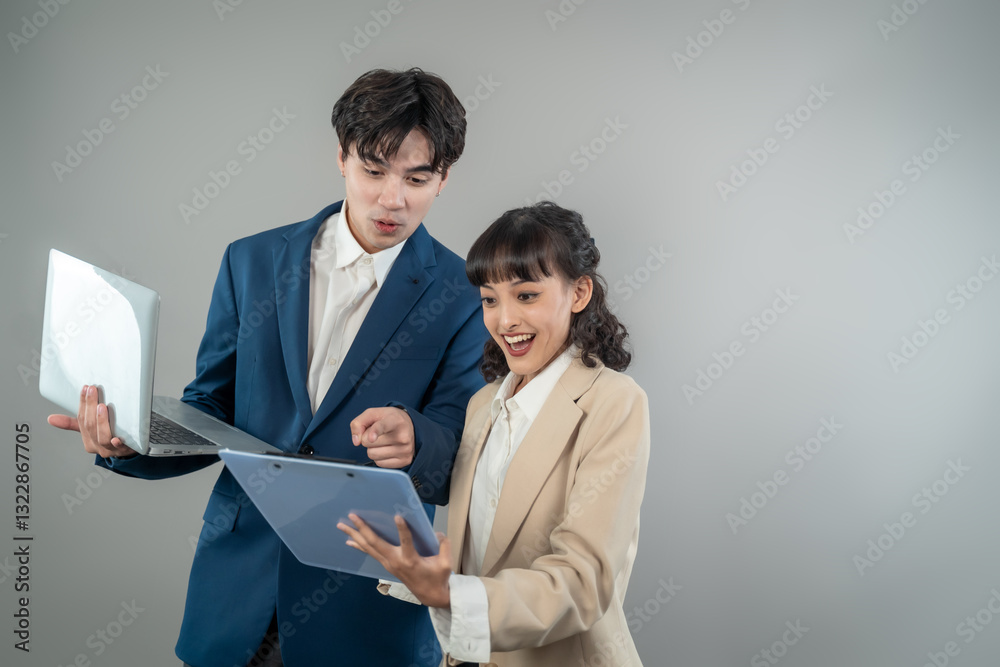 Asian young businessman and woman standing in isolated grey background. Asian young businessman and woman standing in isolated grey background.
