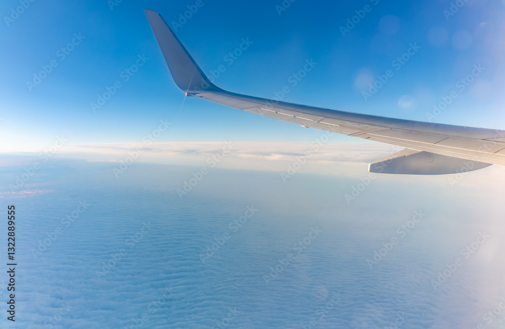Obraz premium View from the airplane window at a beautiful cloudy sky and the airplane wing