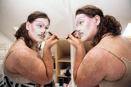 Clown putting on makeup in the mirror before a performance photo