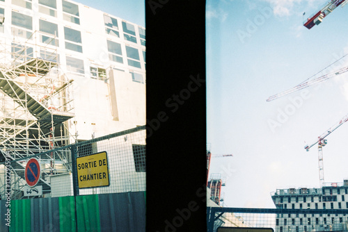 Construction site with cranes and scaffolding under bright sky photo