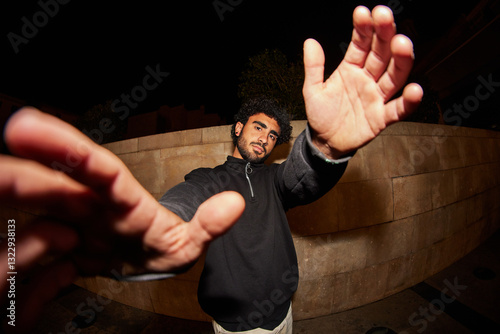 Man showing hands to camera in street in dark place