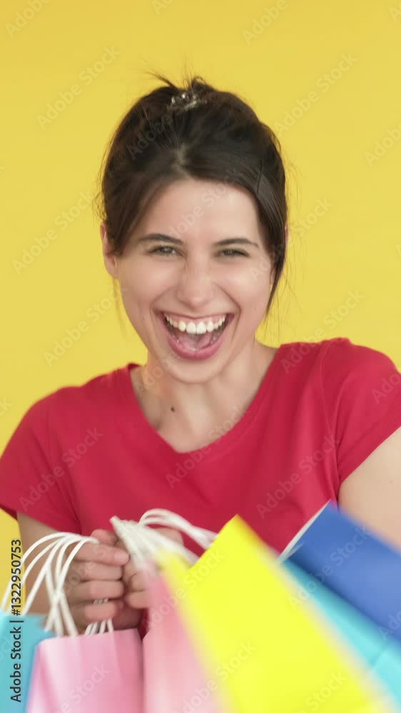 Vertical video. Satisfying surprise. Gift therapy. Excited woman receiving many shopping bag happy joyful delighted client isolated on yellow free space background. Vertical video. Satisfying surprise. Gift therapy. Excited woman receiving many shopping bag happy joyful delighted client isolated on yellow free space background.
