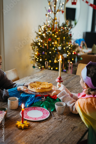 Children Enjoying Epiphany Cake with Crowns at a Festive Table photo