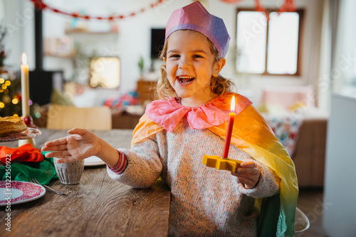 happy bday girl in rainbow attire holding star-shaped candle holder.