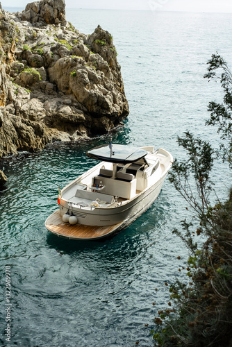 
boat stopped in the sea with rocks around