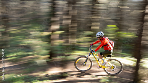 A full body shot, motion-blurred by speed of a mature cyclist training