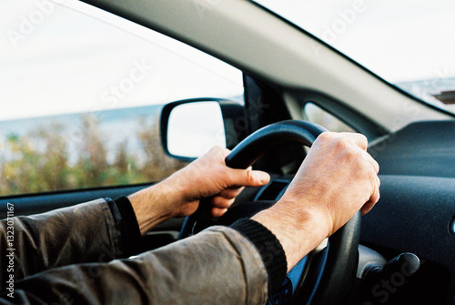 Film photo of man holding a steering wheel of a car