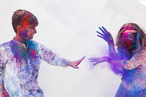 Brother and sister playing holi together with color powder photo