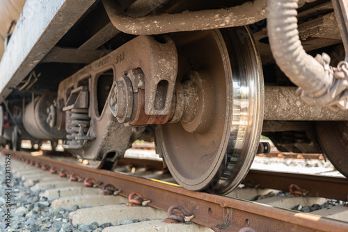 Close-up at freight train wheel part on the rustic railway track. Transportation object.