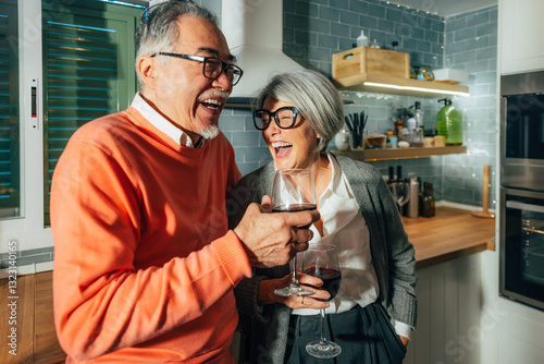 Elderly Multiethnic Couple Enjoying Laughter and Wine in Kitchen