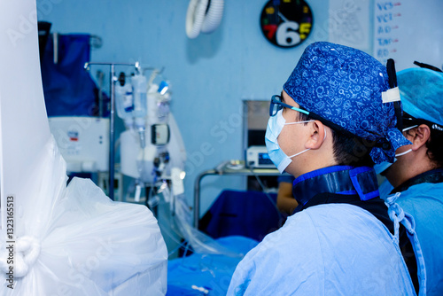 Doctor apuesto concentrado en operación de corazón en quirófano, sala de operación