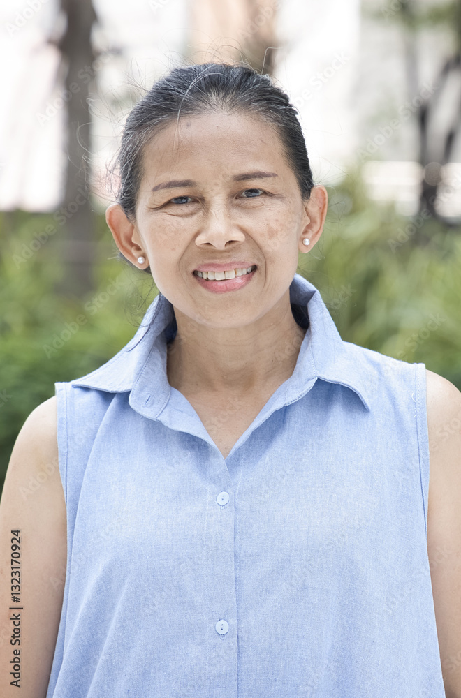 Happy smiling old senior asian woman with positive friendly expression in summer green park in city Happy smiling old senior asian woman with positive friendly expression in summer green park in city