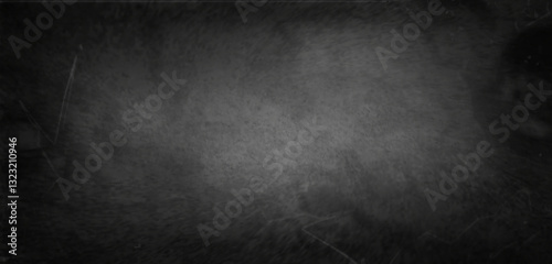 Charcoal wall texture with dark gradient and scratched surface. Grungy blackboard background with subtle lighting in center. Distressed monochrome backdrop for vintage designs or photography overlays.