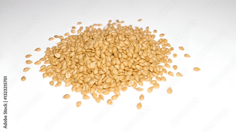 Heap of light brown seeds scattered on white background. Heap of light brown seeds scattered on white background.