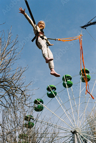 Girl jumping on a trampoline in the park. photo