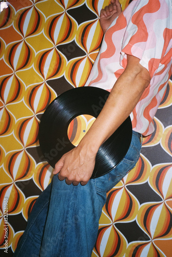man with a disc in front of a wall with a geometric pattern, 35mm