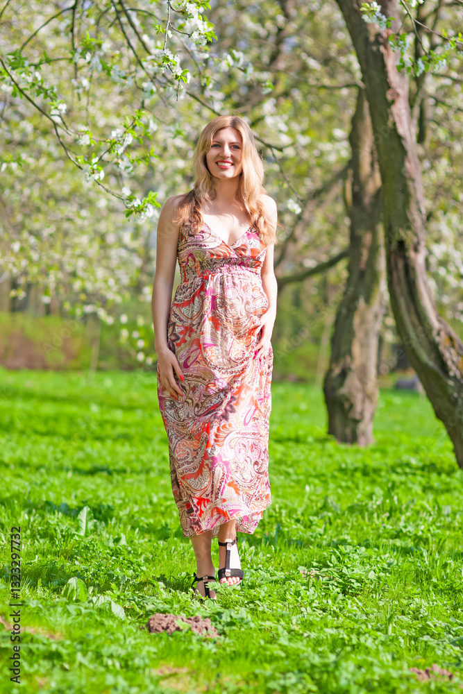 Travel and Vacation Ideas. Portrait of Positive Winsome Alluring Sensual Caucasian Blond Female In Floral Dress Posing in Summer Park Walking Travel and Vacation Ideas. Portrait of Positive Winsome Alluring Sensual Caucasian Blond Female In Floral Dress Posing in Summer Park Walking