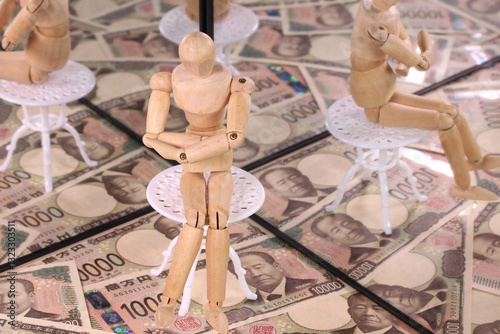 鏡に映る1万円札と木の人形