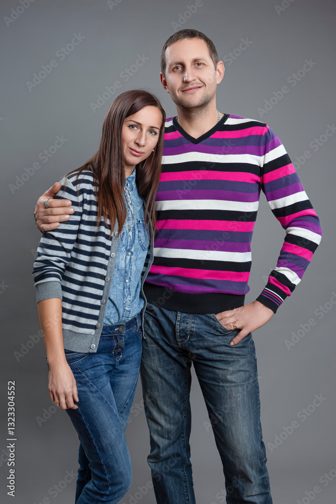 Family Values Concepts. Portrait of One Happy Young Caucasian Couple Posing Together Embraced And Having Good Time Over Gray. Family Values Concepts. Portrait of One Happy Young Caucasian Couple Posing Together Embraced And Having Good Time Over Gray.