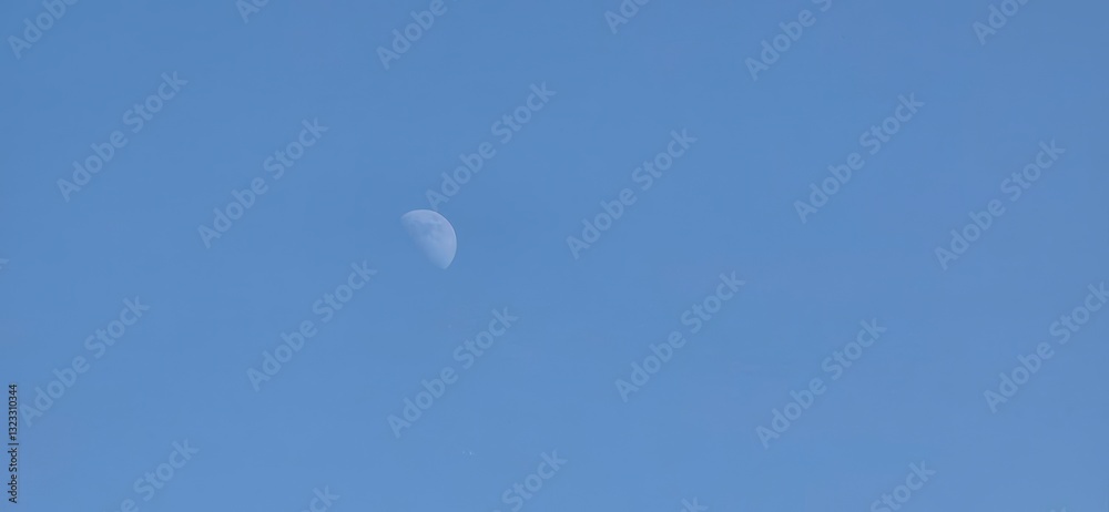 A clear blue sky featuring a crescent moon. Ideal for astronomy, nature themes, or artistic uses in educational content, digital designs, and decor. A clear blue sky featuring a crescent moon. Ideal for astronomy, nature themes, or artistic uses in educational content, digital designs, and decor.