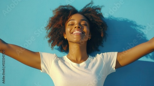 Joyful african female young adult with natural hair smiling against blue background