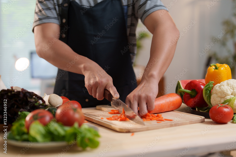 Chef chopping carrots on cutting board, surrounded by fresh vegetables Chef chopping carrots on cutting board, surrounded by fresh vegetables