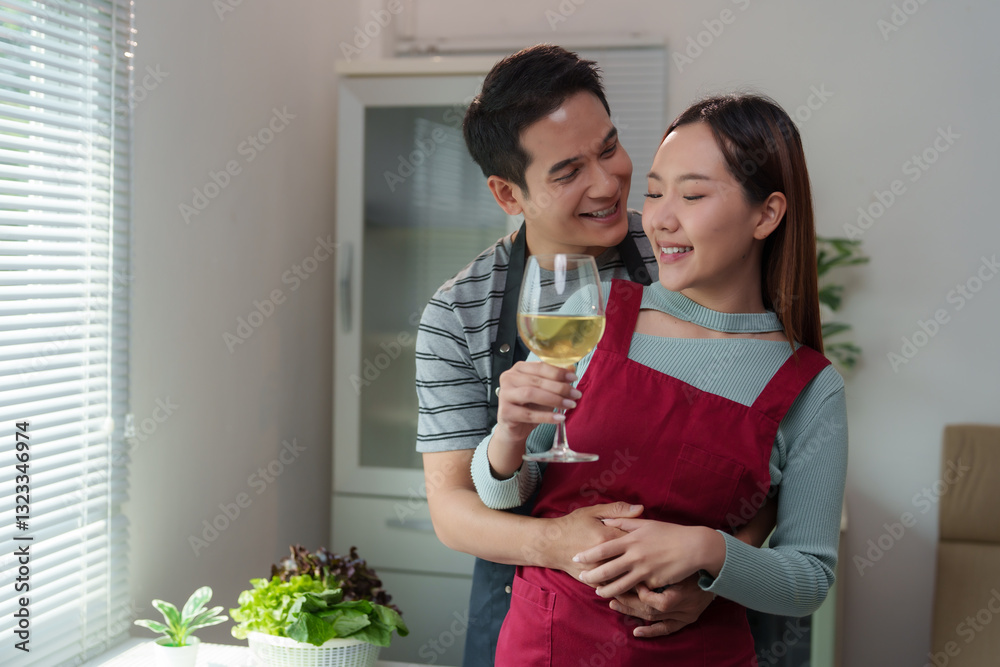 Happy couple embracing and drinking wine in the kitchen Happy couple embracing and drinking wine in the kitchen