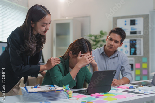 Asian businesswomen comforting stressed colleague in office meeting