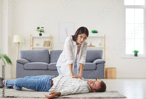 Young wife first aid help, heart attack man, emergency situation, husband lies on floor feeling crushing chest pain, loss of blood supply, shortness of breath, faintness stroke, medical healthcare