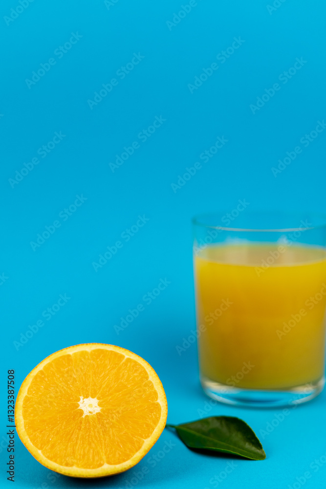 Glass of orange juice in glass close-up. Cut oranges on the table. Glass of orange juice in glass close-up. Cut oranges on the table.