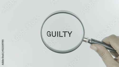 Guilty text or word highlighted by a magnifying glass in a hand on a white background, symbolizing feelings of responsibility, remorse, and accountability