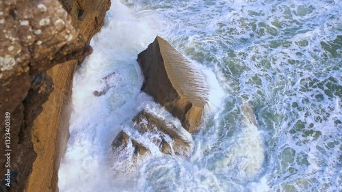 Foaming sea waves wash over the rocks