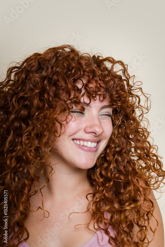Portrait of woman with long curly red hair winking