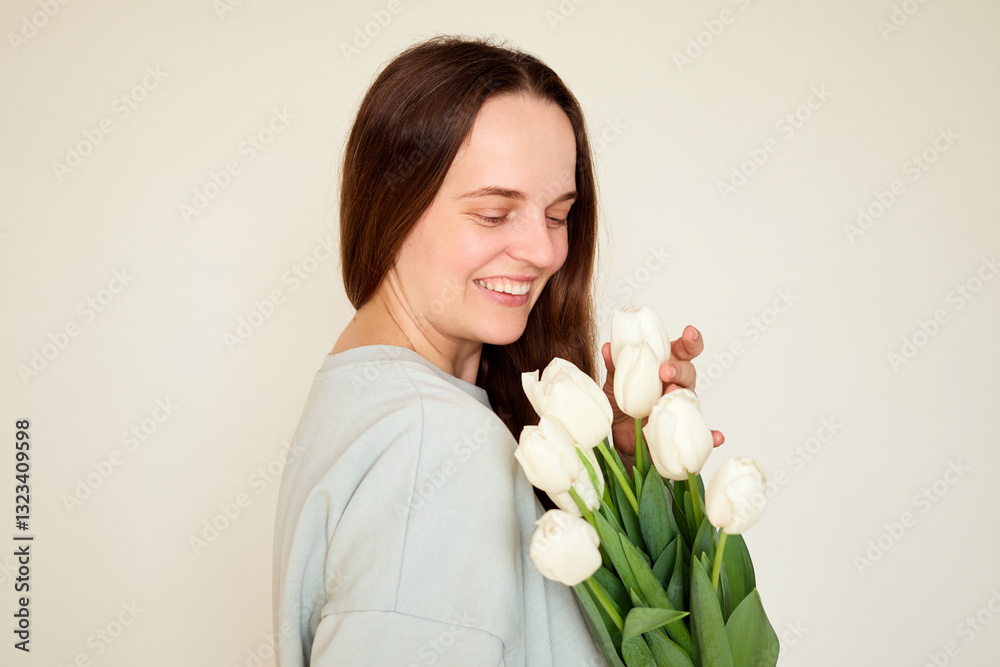 A woman joyfully embraces a bouquet of white tulips in a well-lit indoor space. Her gentle smile reflects happiness and appreciation for the flowers A woman joyfully embraces a bouquet of white tulips in a well-lit indoor space. Her gentle smile reflects happiness and appreciation for the flowers
