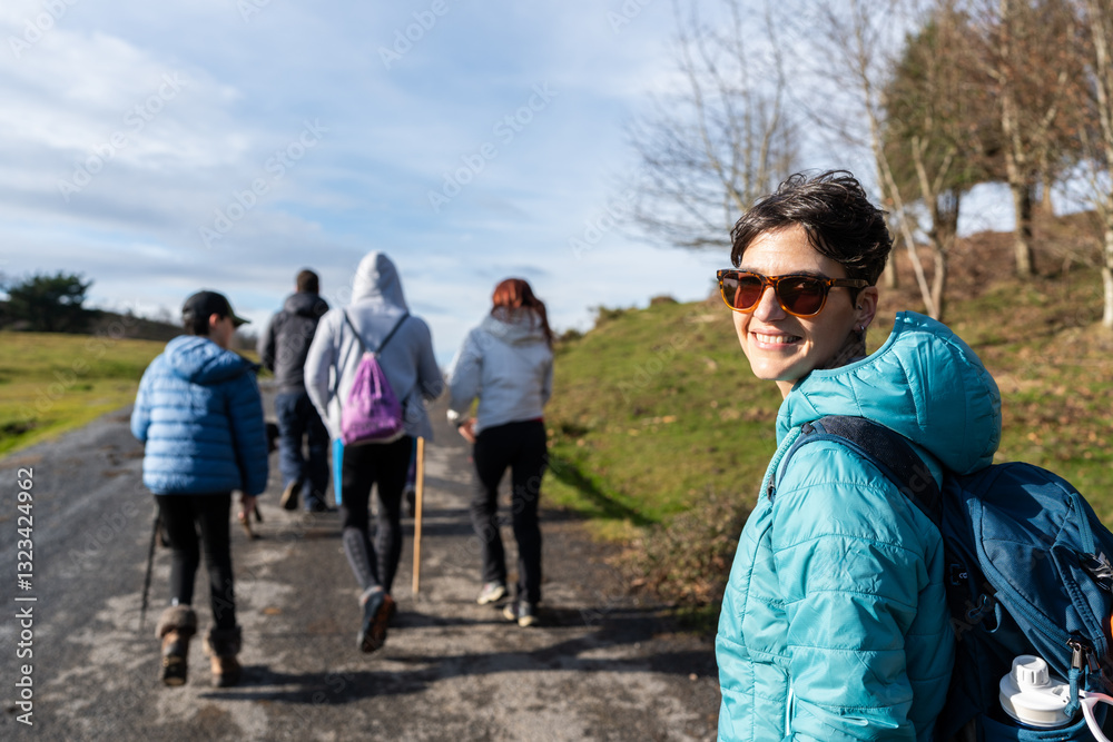 Group of hikers walking in Spain, woman smiling at camera Group of hikers walking in Spain, woman smiling at camera