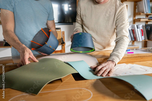 Two people examining colorful design prototypes and materials on a wooden table in a workshop. Nijmegen, Netherlands photo