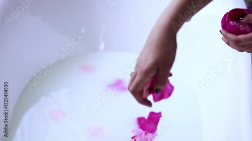 Throws flowers into a tub of milk. Spa treatments